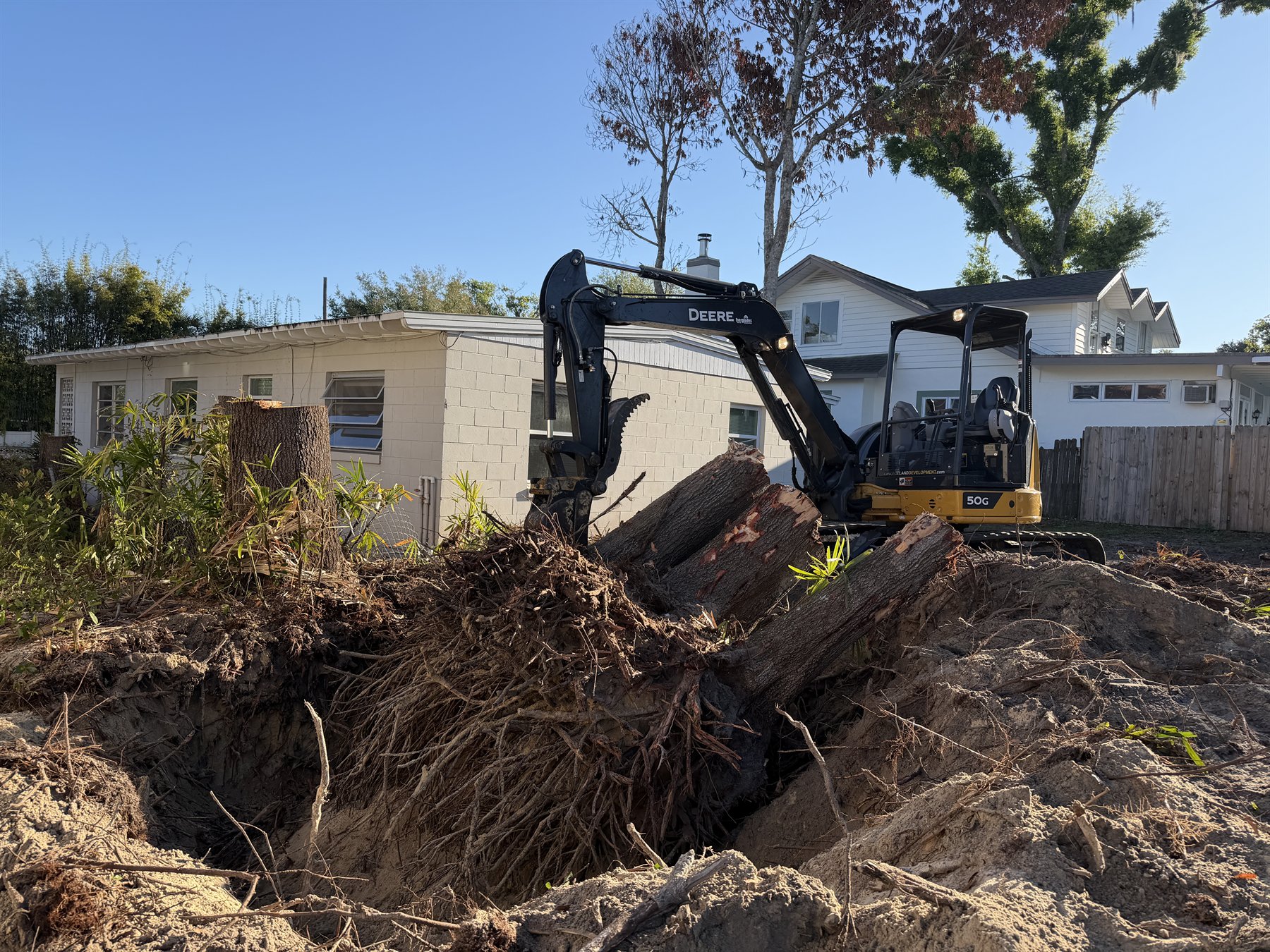 Excavator removing roots during site preparation