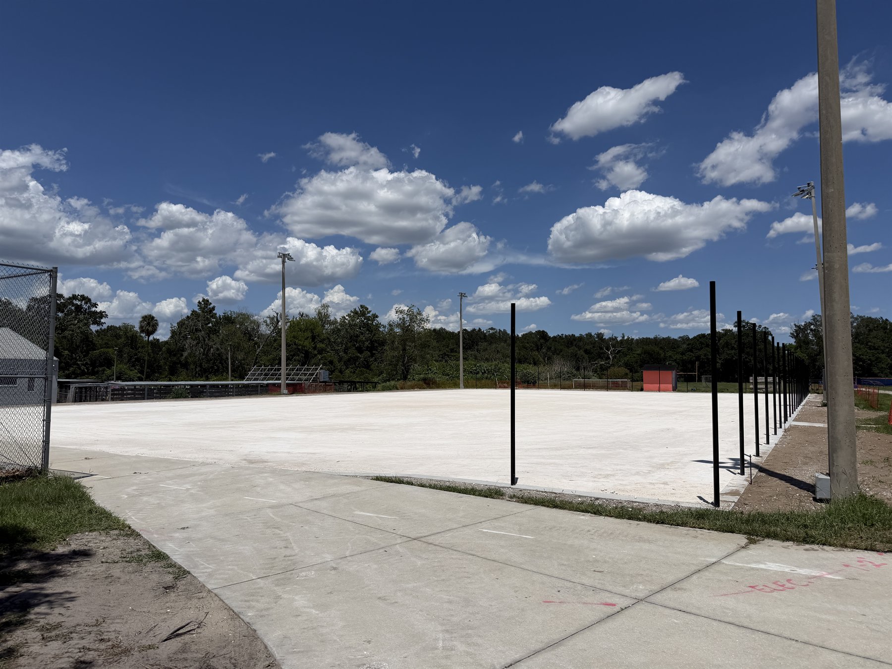 Laser grading equipment working across a sport court base